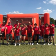 Mitspielende beim Human-Soccer-Turnier mit hochgerecktem Daumen in roter Kleidung auf Kunstrasen eines Sportplatzes.